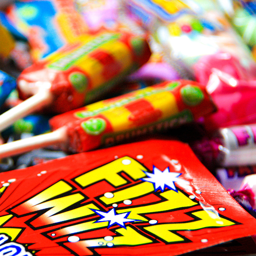 A close up of the contents of our Penny Post Retro Sweets letterbox hamper - filled with classic sweets including Drumstick & Fizz WIzz sherbert sweets.